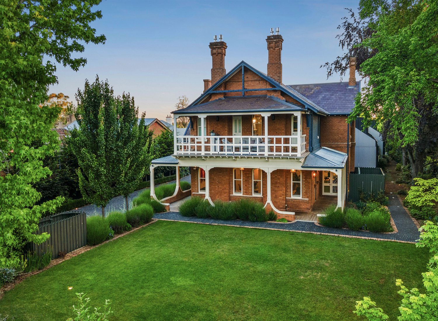 The restored 1896 homestead at Yallungah Boutique Hotel, Orange NSW, its verandahs lit at dusk