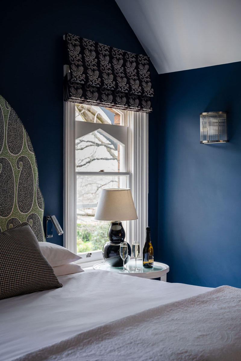 Cozy bedroom corner with wine and lamp near window