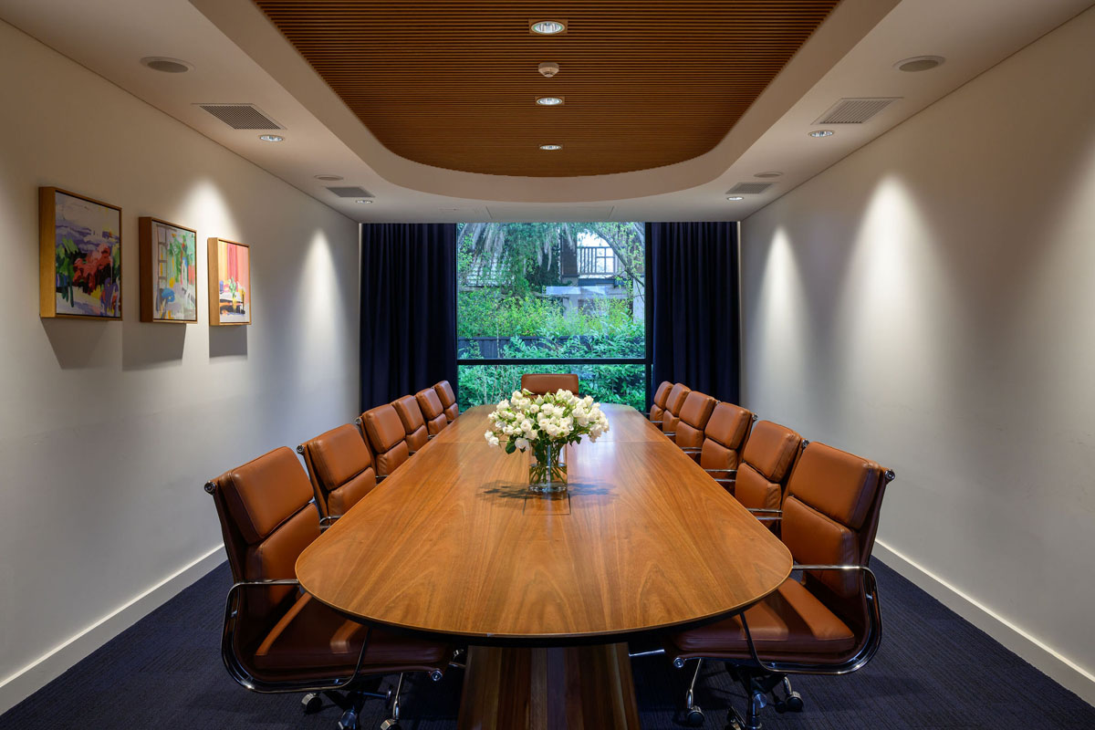 Conference room with wooden table, leather chairs, and flowers in vase