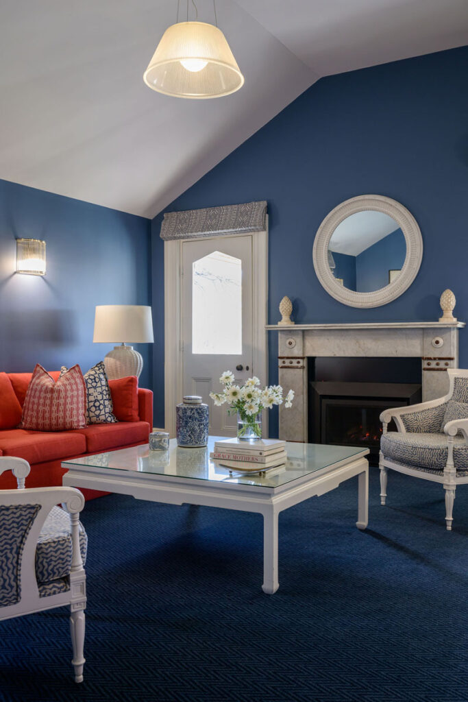 Living room with blue walls, red sofa, white coffee table, and fireplace