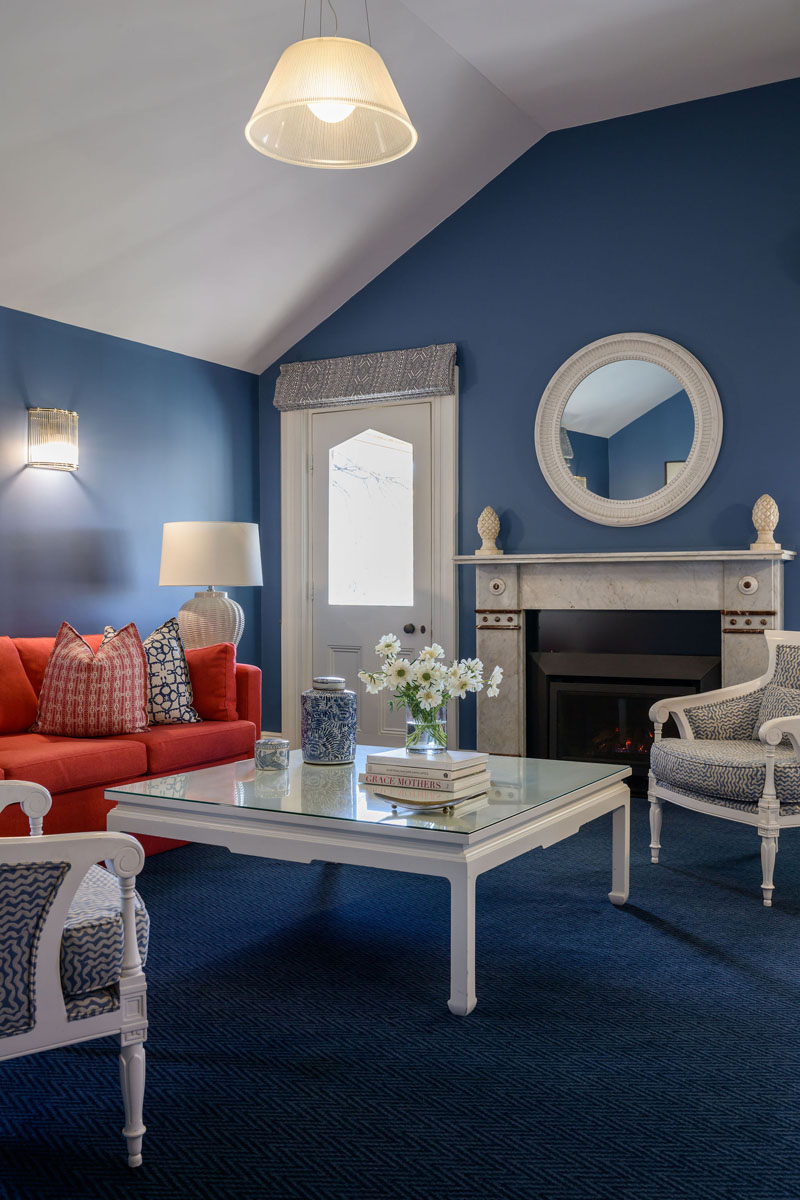 Living room with blue walls, red sofa, white coffee table, and fireplace