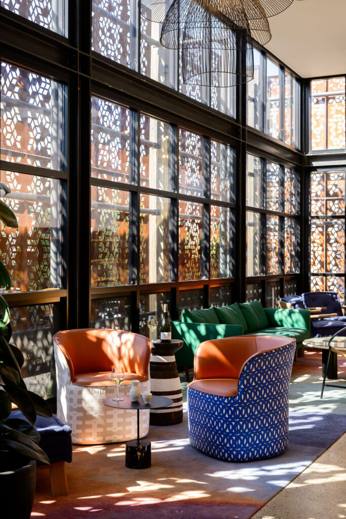 Contemporary lounge with patterned windows and vibrant seating