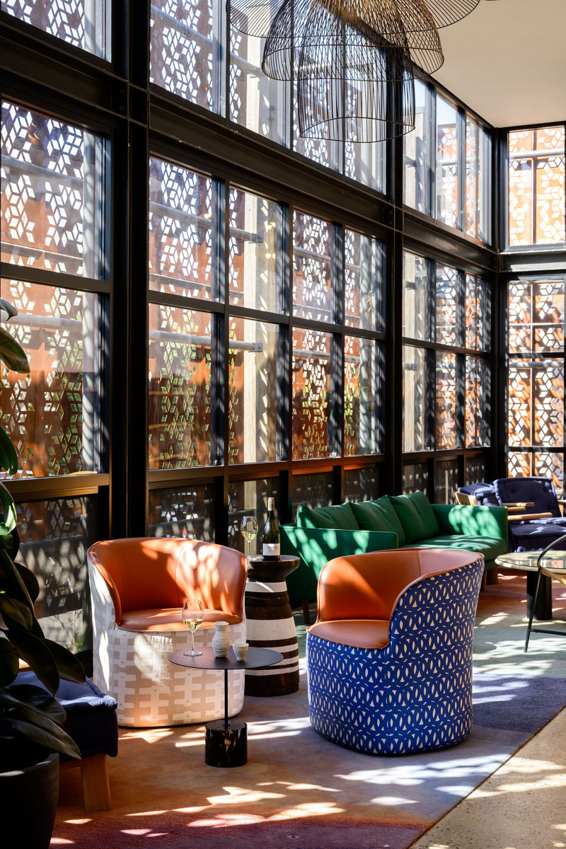 Contemporary lounge with patterned windows and vibrant seating